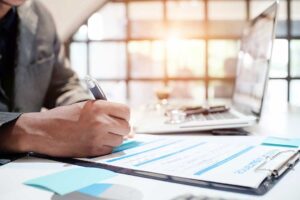 Patient reviewing surgery coverage documents with an insurance form and medical records on a desk.
